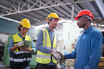 Team maintenance engineers men and women inspect relay protection system with laptop comp. They work a heavy industry manufacturing factory.
