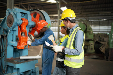 Team maintenance engineers men and women inspect relay protection system with laptop comp. They work a heavy industry manufacturing factory.