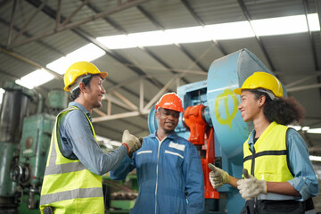 Team maintenance engineers men and women inspect relay protection system with laptop comp. They work a heavy industry manufacturing factory.