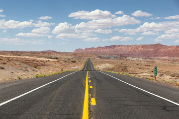 Scenic Road in the Dry Desert with Red Rocky Mountains in Background. Near Page, Arizona, United States of America. Adventure Travel