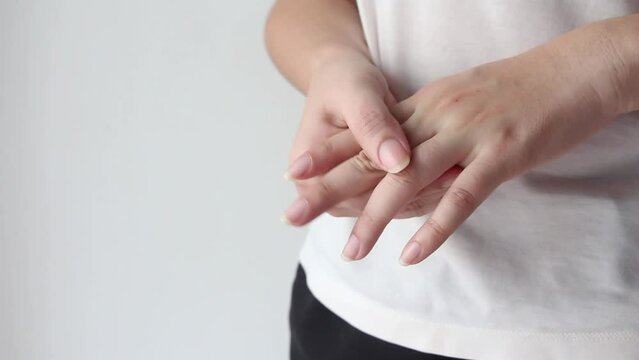 Young female suffering from pain in hands and massaging her painful hands. hurt include carpal tunnel syndrome, fractures, arthritis or trigger finger, Peripheral neuropathy.	