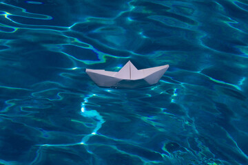 Sailing yacht concept, paper ship with sailing boat. Paper ship sail. Paper boat on the sea water background. Dreaming traveling.