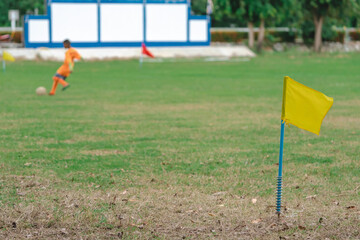 A simple yellow flag on the corner of football field in school. Place for corner kick on soccer...
