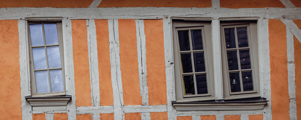 Fototapeta na wymiar Half timbered house background with brown yellow pattern of wood and plaster and crooked windows