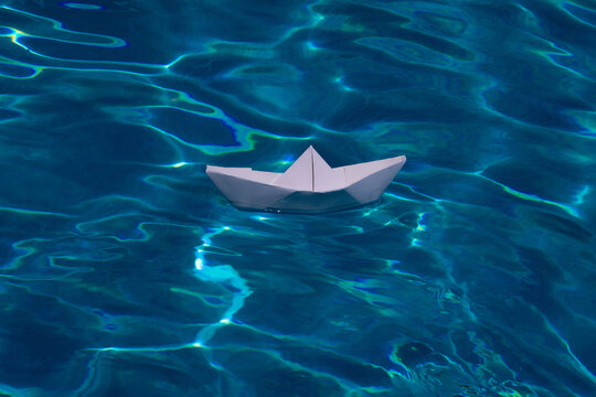 Sailing yacht concept, paper ship with sailing boat. Paper ship sail. Paper boat on the sea water background. Dreaming traveling.