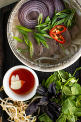 Vietnamese Pho Bo soup with beef hot peppers and bread flatbread close-up
