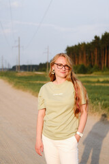 Blondie long haired woman in eyeglasses walk oudoor near park