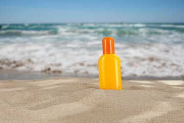 Sunbathing oil in the sand with a vacant spot on the beach by the sea on a beautiful sunny day