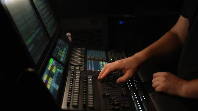Lighting technician works on the lighting console at a live show concert event