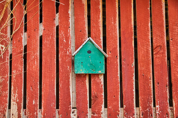 Turquoise birdhouse on faded red barnwood side