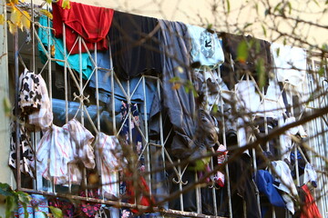 Fototapeta na wymiar Washed linen dries on the street outside the window of the house.