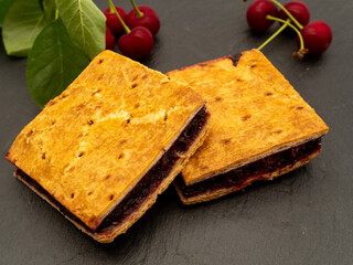 fresh homemade sour cherry pie and sour cherries on slate