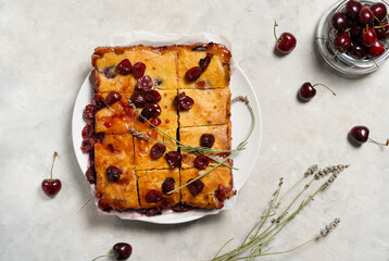 Fresh baked sweet cherry pie or red brownie cake on plate with lavender and raw berries aside.