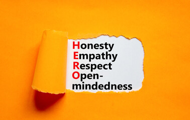 HERO honesty empathy respect open-mindedness symbol. Concept words HERO honesty empathy respect open-mindedness on white paper, orange background. HERO honesty empathy respect open-mindedness concept.