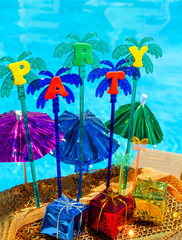 The concept for an invitation to a party bright umbrellas on the background of the pool.