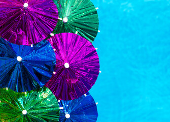 The concept for an invitation to a party bright umbrellas on the background of the pool.