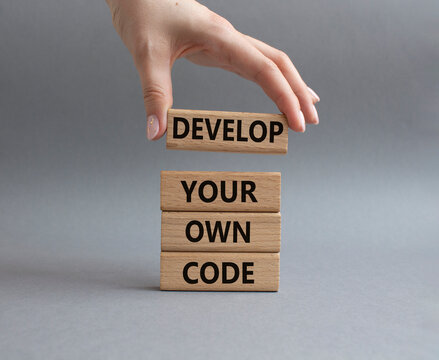 Develop your own code symbol. Concept words Develop your own code on wooden blocks. Beautiful grey background. Business and Develop your own code concept. Copy space.