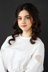Beauty portrait of a pretty young woman wear white shirt, posing in a studio, isolated black background.