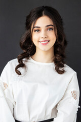 Closeup front portrait of a pretty young woman wear white shirt, posing in a studio, isolated grey background.