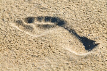Fototapeta na wymiar Texture beach sand with footsteps