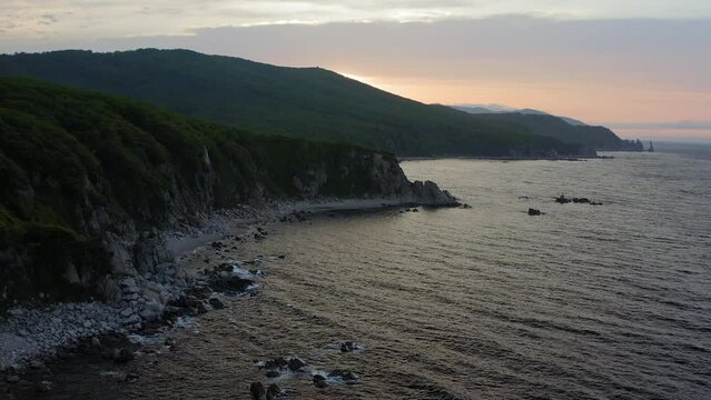 Sea stack vertically sticking out of the water at dawn. Drone view, panoramic view. Cape Laplace, East Sea