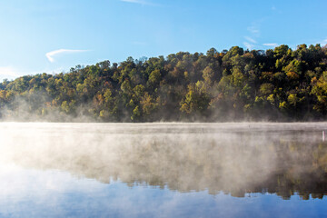 Fog over a lake with a forest in the background