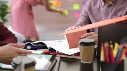 A busy team of creatives working together and sharing information in an office. A group of employees collaborating on a project with a deadline at the workplace. Closeup of productive colleagues