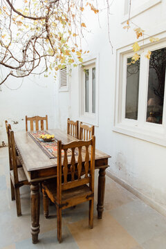 Breakfast nook with chairs and a table under vines in a small