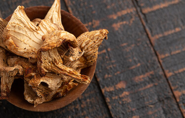 Bowl of Sliced and Dried Chanterelle Mushrooms on a Rustic Wooden Table