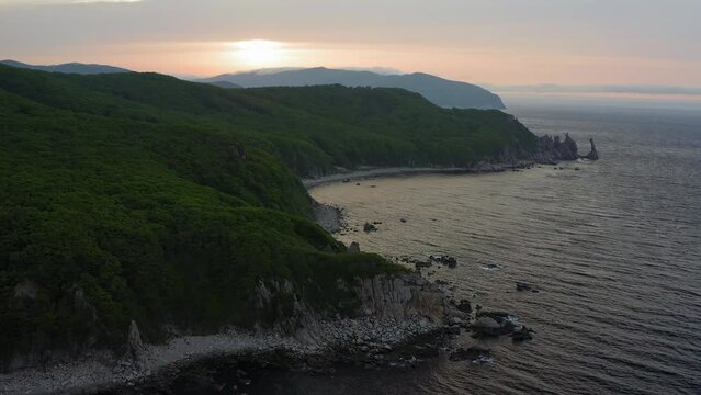 Sea stack vertically sticking out of the water at dawn. Drone view, panoramic view. Cape Laplace, East Sea