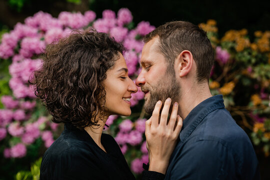 Portrait of a couple in rhododendrons looking in love