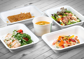 A set of healthy food dishes in ecological packaging on a wooden background. Food delivery. Takeaway.