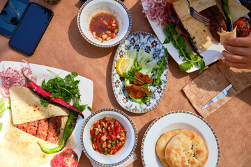 Kebab with pita bread, salad, cigkofte and other traditional turkish dishes. Traditional turkish dinner top down view.