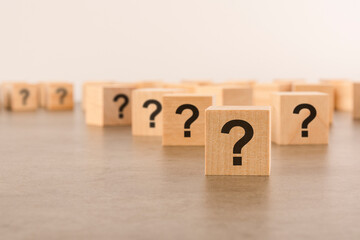 front view on many wood cubes with question marks. many question arising concept