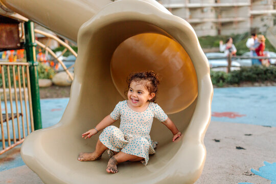 Joyful young girl with limb difference on slide