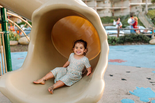 Happy young girl with limb difference on slide