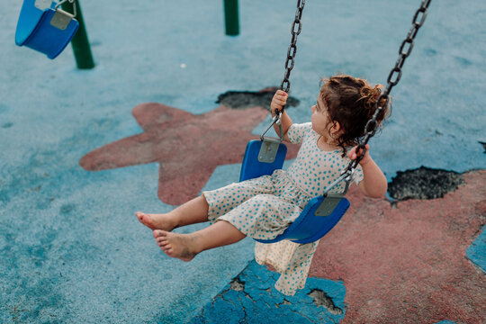 Barefoot young girl on swing
