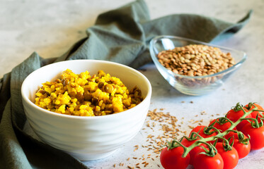 Mujadara made of lentils and rice on a concrete background with gray textiles