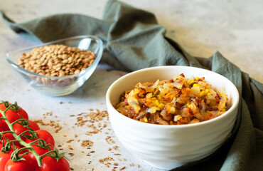 Mujadara: lentils, rice and fried onions on light background with gray textiles