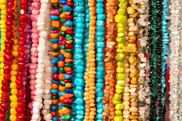 Colorful beads threads made of natural semiprecious stones background. Isolated jewelry close up....