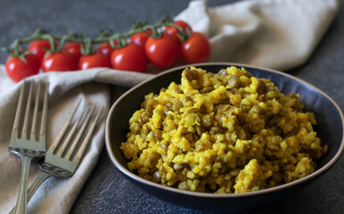 Mujadara made of lentils and rice on a dark background with light textiles