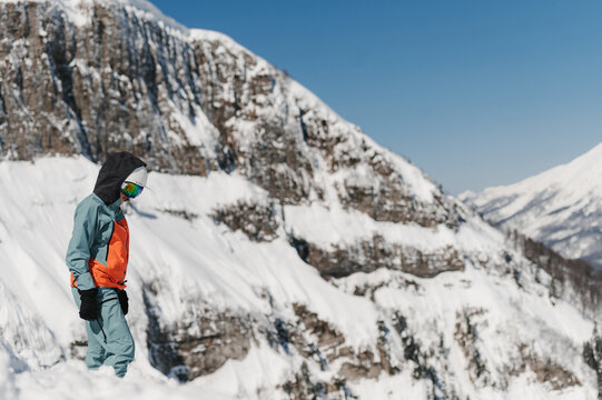 Sportswoman standing on snowy mountain slope