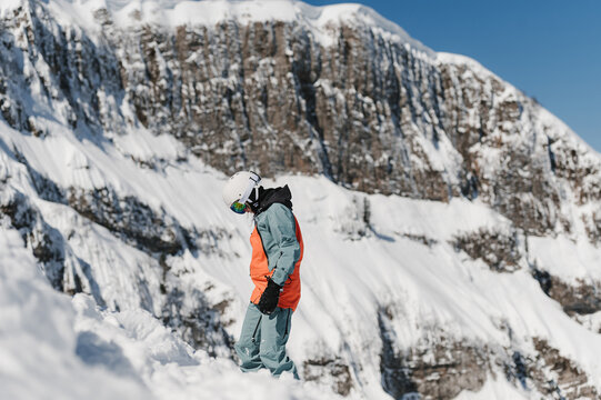Anonymous skier standing against snowy mountains