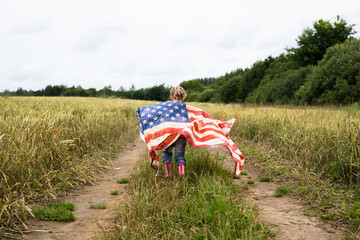 Little girl with american flag on the field