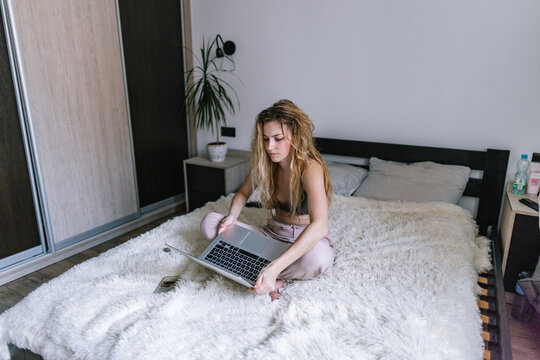 Woman sitting on plaid and holding notebook computer