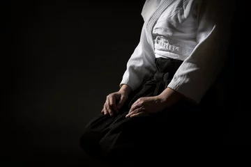 Foto op Plexiglas Aikido sitting pose in hakama uniform on black background. Shallow depth of field. SDF. © fotoyou