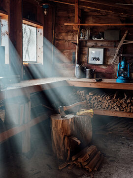 Light beams enter a dusty woodshed. 