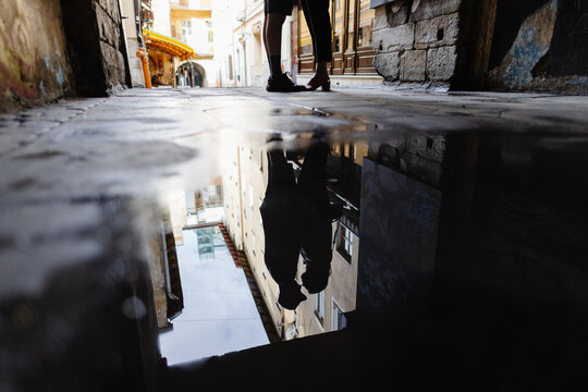 Reflection silhouettes of romantic couple in rain puddle 