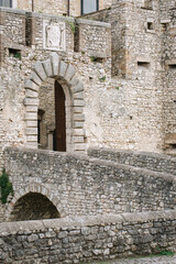 Medieval castle of Orsini Odescalchi in Nerola, Rome close-up. Arched passage, stone bridge, stone...