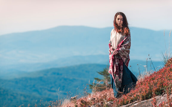 The young woman in traditional clothes among the mountains